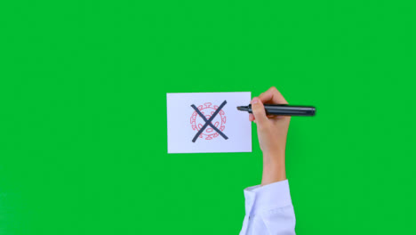 Doctor-Drawing-an-X-Over-Pathogen-Illustration-on-Paper-with-Green-Screen